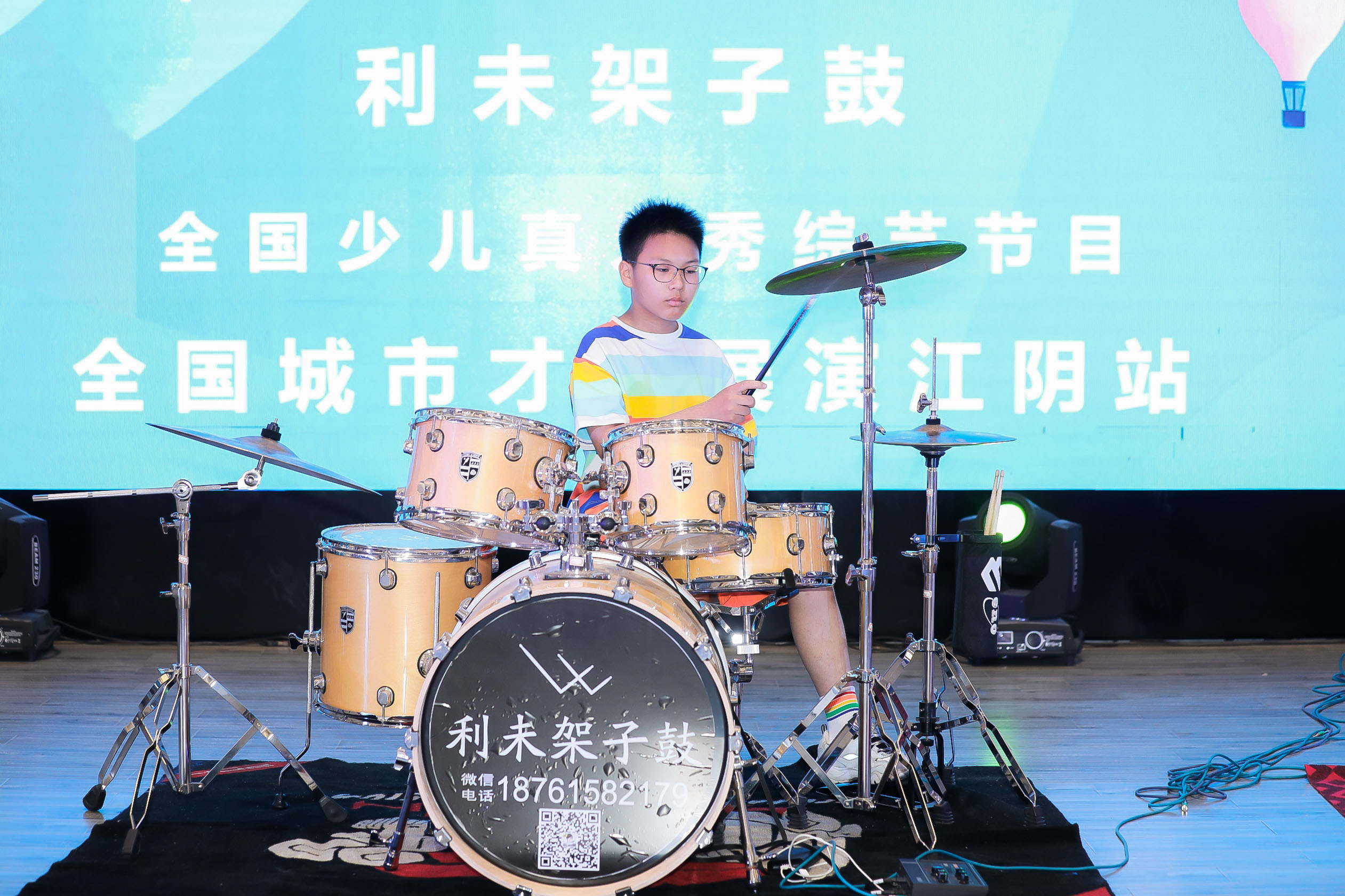`利未架子鼓学员在 2021 江阴红星美凯龙少儿架子鼓比赛中进行现场演奏,展示稳定节奏与舞台专注力。
